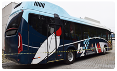 Ônibus a hidrogênio, cor azul escuro, azul claro e branco, trafegando pela via.