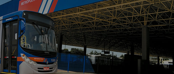 Foto de um Terminal com um ônibus estacionado na parte da frente.